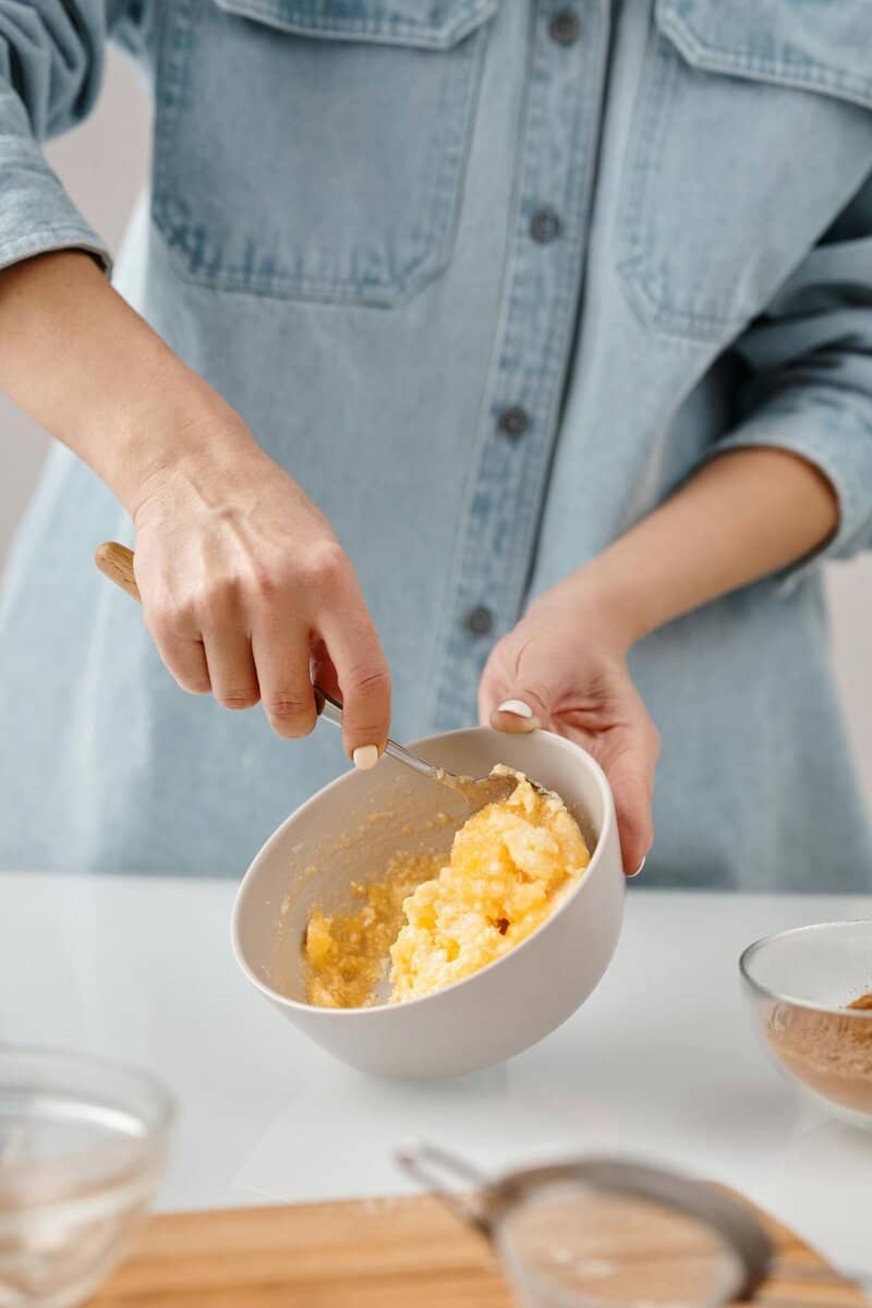 Hands stirring dough in a bowl, highlighting the home baking process.